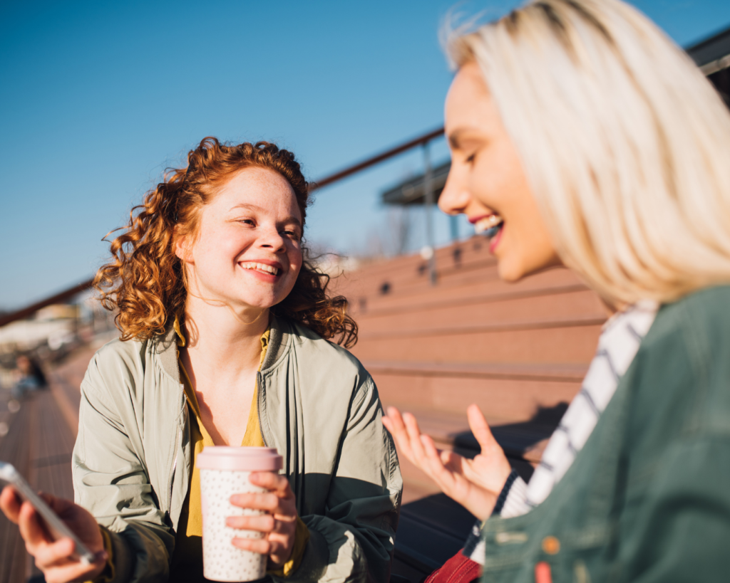 The &Quot;Mud Season&Quot; Manifesto: Why Spring Is Colorado’s Best-Kept Secret 4 Two women laughing and drinking coffee while sitting outside in denver colorado during the spring.