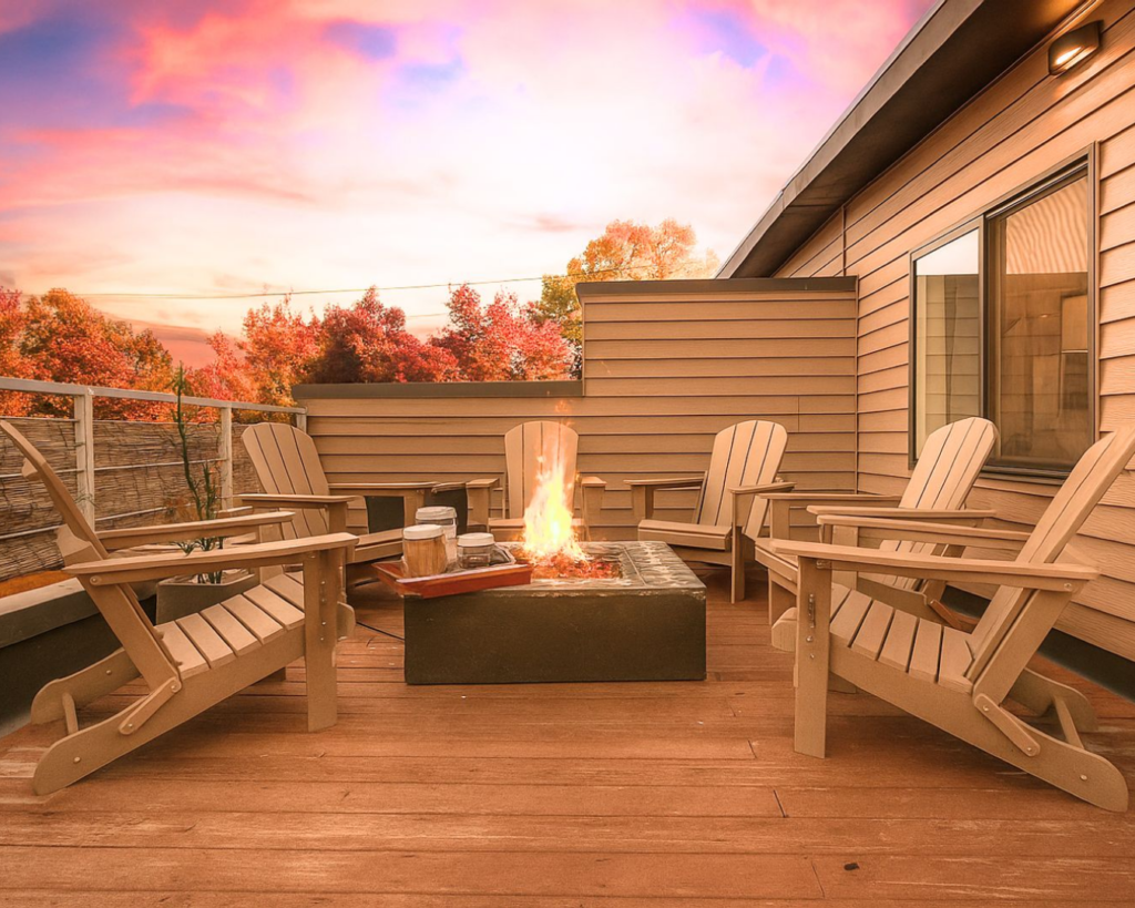 Outdoor deck at sunset with a fire pit and mountain views