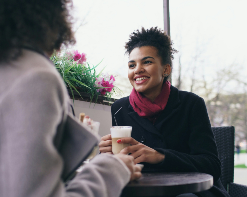 Two people enjoying drinks at an outdoor denver cafe during a relaxed summer outing.