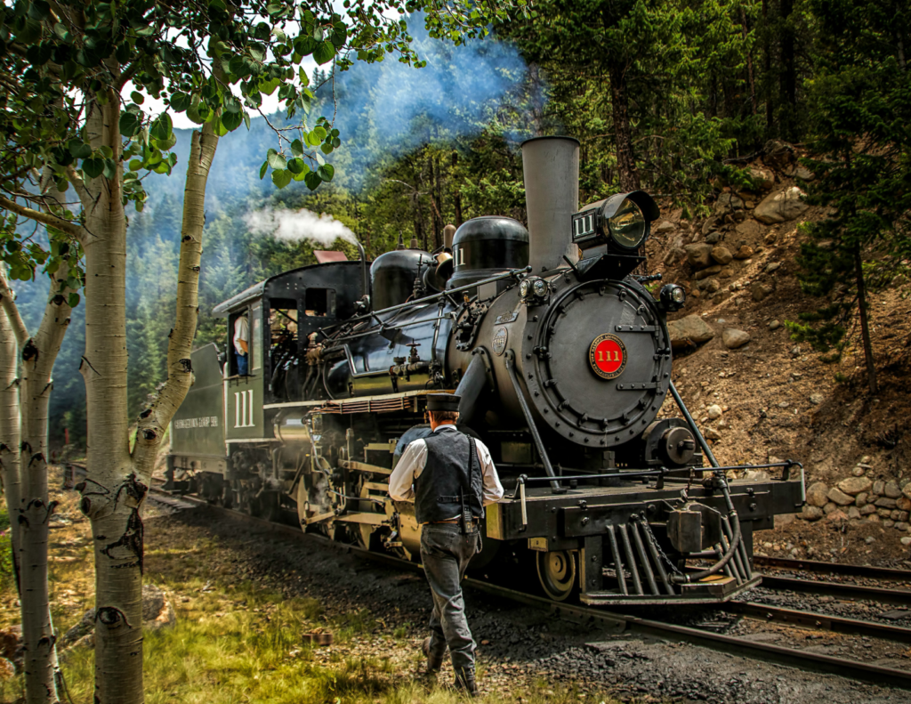 Best Colorado Towns For A Relaxing Colorado Weekend Trip 6 Historic steam train traveling through a wooded mountain area near georgetown, colorado.